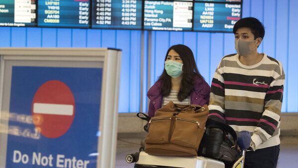 Des passagers portant un masque de protection dans l'aéroport de Los Angeles, le 22 janvier 2020. - Sputnik Afrique