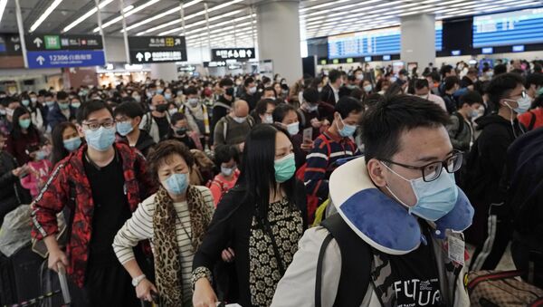 Passengers wear protective face masks at the departure hall of a high speed train station in Hong Kong - Sputnik Afrique