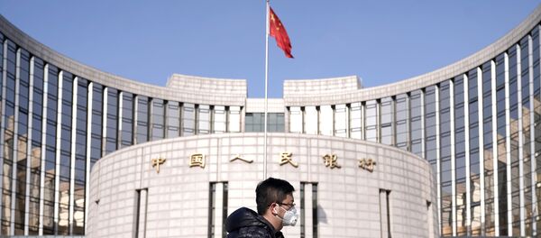 A man wearing a mask walks past the headquarters of the People's Bank of China, the central bank, in Beijing, China, as the country is hit by an outbreak of the new coronavirus, February 3, 2020 - Sputnik Afrique