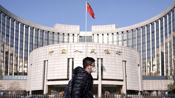 A man wearing a mask walks past the headquarters of the People's Bank of China, the central bank, in Beijing, China, as the country is hit by an outbreak of the new coronavirus, February 3, 2020 - Sputnik Afrique