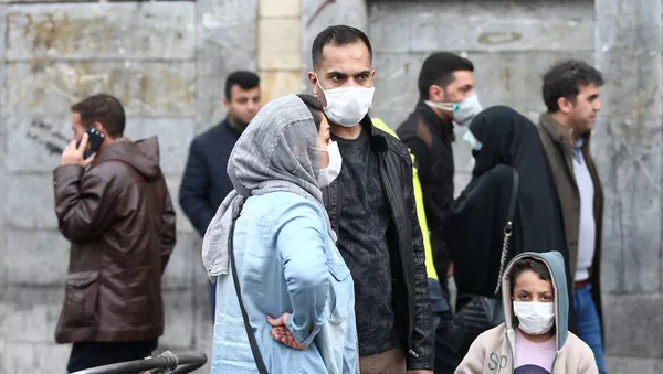 Iranian family wear protective masks to prevent contracting a coronavirus, as they stand at Grand Bazaar in Tehran, Iran February 20, 2020.  - Sputnik Afrique