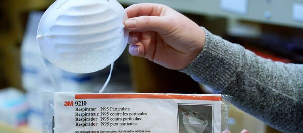 A standard dust & particle mask, and an N95 medical respirator mask (bottom), that are part of personal protection and survival equipment kits ordered by customers preparing against novel coronavirus, are seen at Nitro-Pak in Midway, Utah, U.S. February 27, 2020.  REUTERS/George Frey - Sputnik Afrique