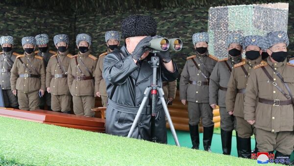 North Korean leader Kim Jong-un looks into binoculars during a missile test. - Sputnik Afrique