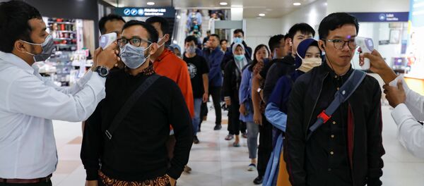 Los médicos miden la temperatura de los pasajeros debido al brote de coronavirus - Sputnik Afrique