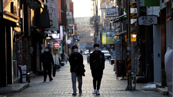Pedestrians wearing masks amid the rise in confirmed cases of the novel coronavirus disease of COVID-19, make their way at a shopping district in Daegu, South Korea, March 4, 2020 - Sputnik Afrique