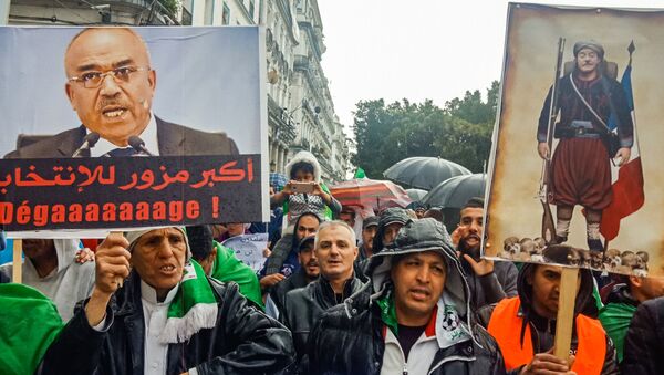 Des Algériens brandissent des pancartes contre l’ancien Premier ministre Ahmed Ouyahia. - Sputnik Afrique