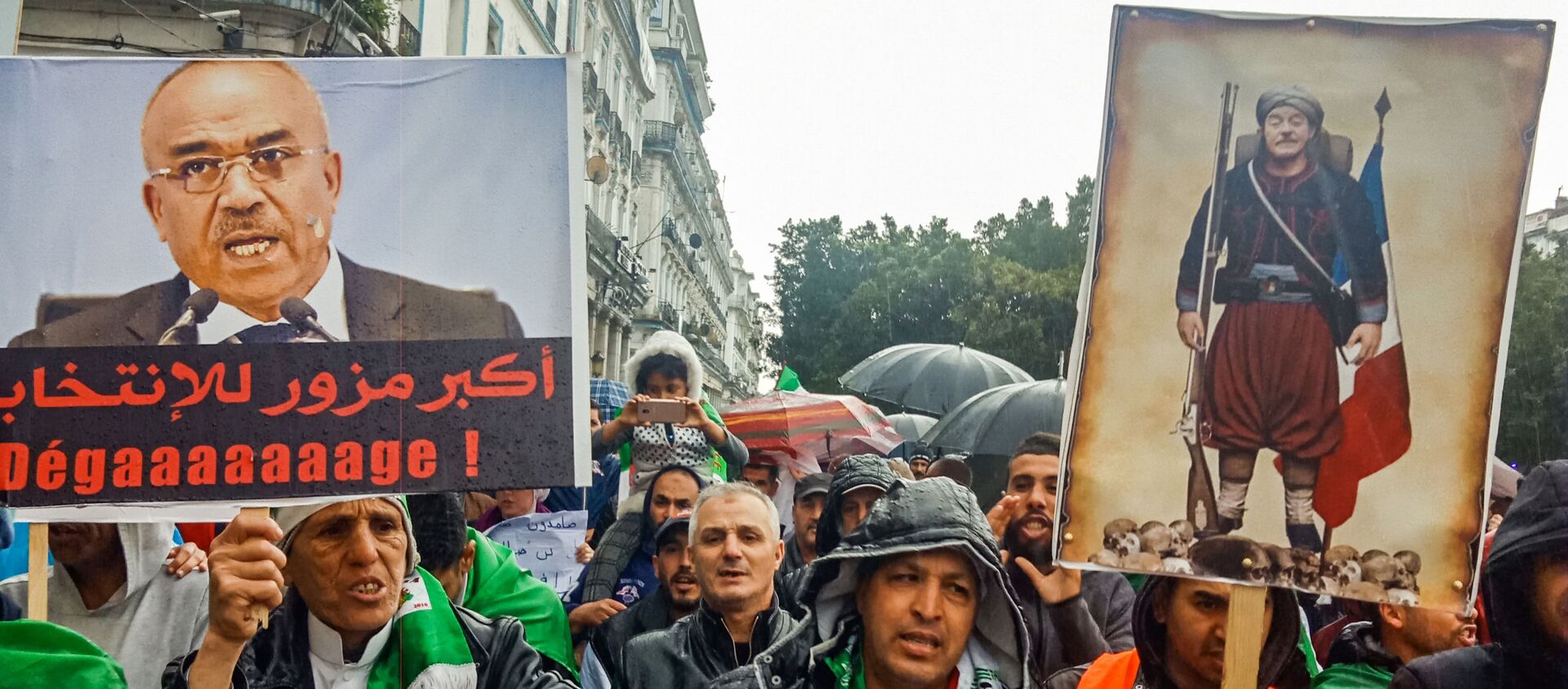 Des Algériens brandissent des pancartes contre l’ancien Premier ministre Ahmed Ouyahia. - Sputnik Afrique, 1920, 06.03.2020
