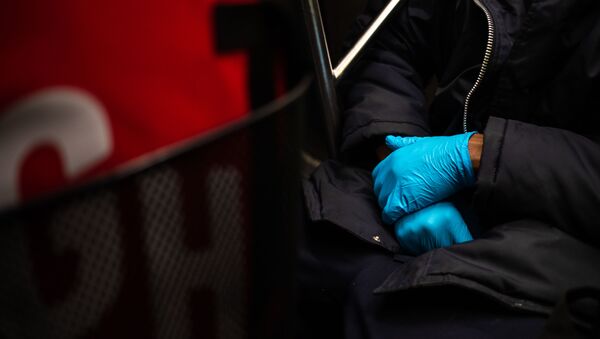 A man wearing a protective glove is seen on the subway on March 10, 2020 in New York City. There are now 20 confirmed coronavirus cases in the city including a 7-year-old girl in the Bronx.   Jeenah Moon/Getty Images/AFP - Sputnik Afrique