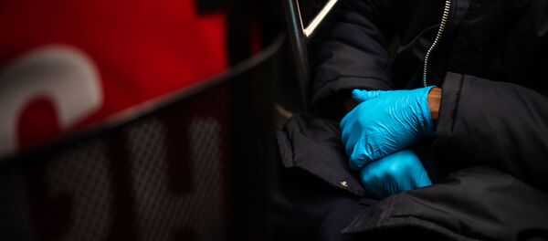 A man wearing a protective glove is seen on the subway on March 10, 2020 in New York City. There are now 20 confirmed coronavirus cases in the city including a 7-year-old girl in the Bronx.   Jeenah Moon/Getty Images/AFP - Sputnik Afrique