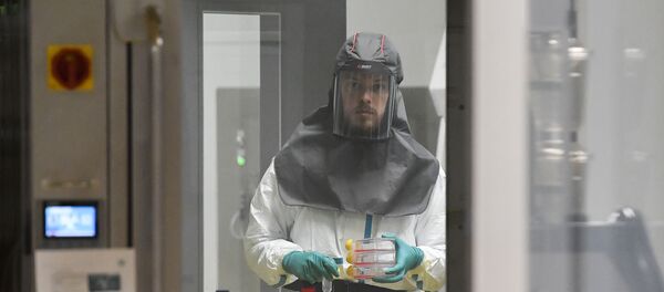 A virologist working on finding a treatment against COVID-19, the novel coronavirus, holds samples at a level 3 laboratory at the Rega Institute for Medical Research at the University of Leuven, on February 28, 2020. - The number of new coronavirus cases in the world rose to 83,853, including 2,873 deaths, across 56 countries and territories by 1300 GMT on February 28, 2020, according to a report gathered by AFP from official sources. (Photo by JOHN THYS / AFP) - Sputnik Afrique