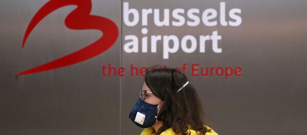 A woman wearing a protective face mask, due to a coronavirus outbreak, is seen at Zaventem international airport near Brussels - Sputnik Afrique