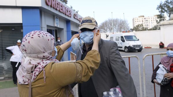 Des personnes portant des masques devant une clinique à Alger - Sputnik Afrique