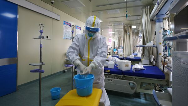 Medical workers in protective suits disinfect an intensive care unit (ICU) ward of Union Jiangbei Hospital in Wuhan, the epicentre of the novel coronavirus outbreak, Hubei province, China March 12, 2020. Picture taken March 12, 2020 - Sputnik Afrique