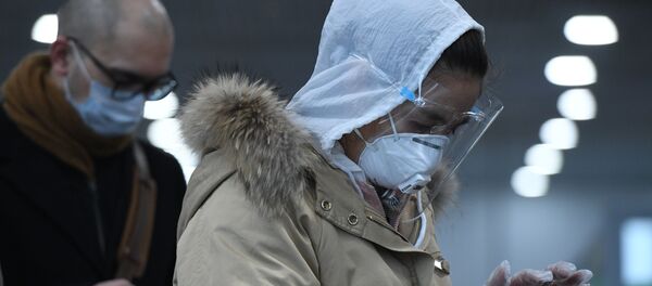 Des voyageurs portant des masques médicaux (archive photo) Des voyageurs portant des masques médicaux (archive photo) - Sputnik Afrique