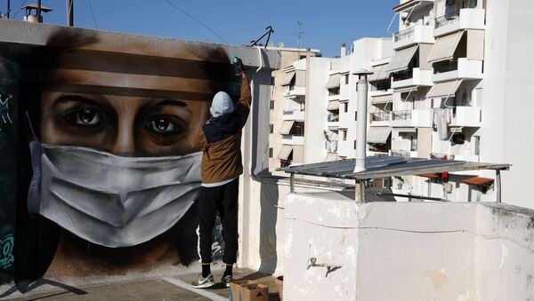 Un jeune artiste grec réalise un graffiti à l’effigie d’une femme portant un masque.   - Sputnik Afrique