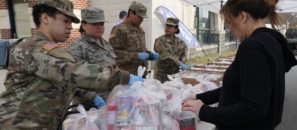 National Guard troops give food to residents of New Rochelle, New York at New Rochelle High School March 12, 2020 - Sputnik Afrique