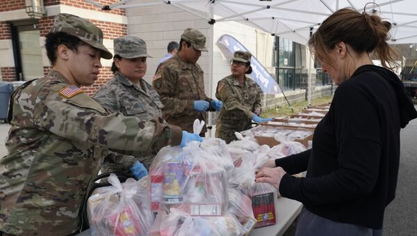 National Guard troops give food to residents of New Rochelle, New York at New Rochelle High School March 12, 2020 - Sputnik Afrique