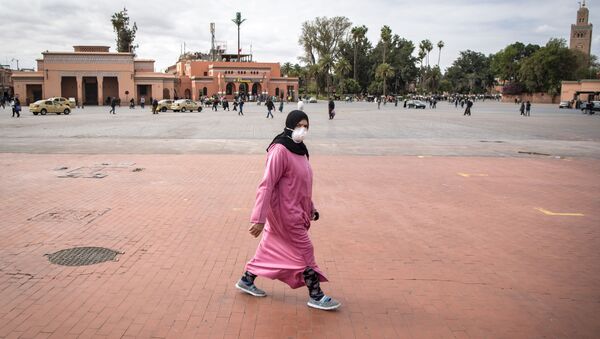 Une Marocaine traverse la place Jemaa el-Fna à Marrakech, désertée à cause de la pandémie de coronavirus. - Sputnik Afrique