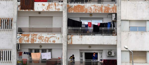 Un homme fume sur son balcon pendant le confinement à Tunis. - Sputnik Afrique