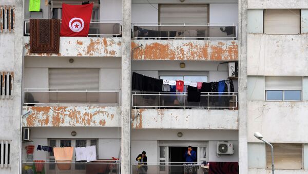 Un homme fume sur son balcon pendant le confinement à Tunis. - Sputnik Afrique