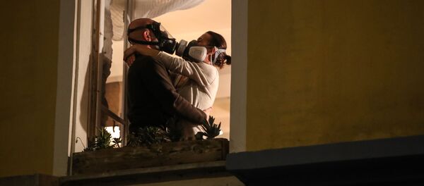 Un homme et une femme en masques à la fenêtre à Nice, le 24 mars 2020 - Sputnik Afrique