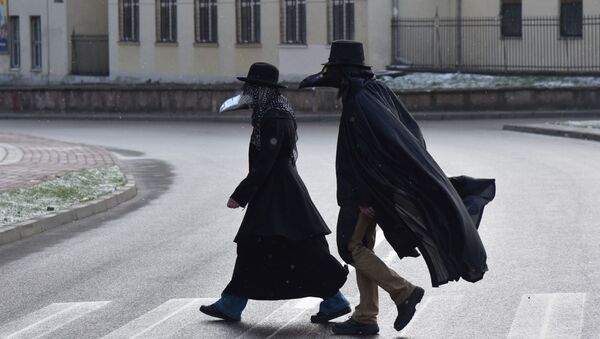 Des gens portant des costumes du médecin de peste en Ukraine - Sputnik Afrique