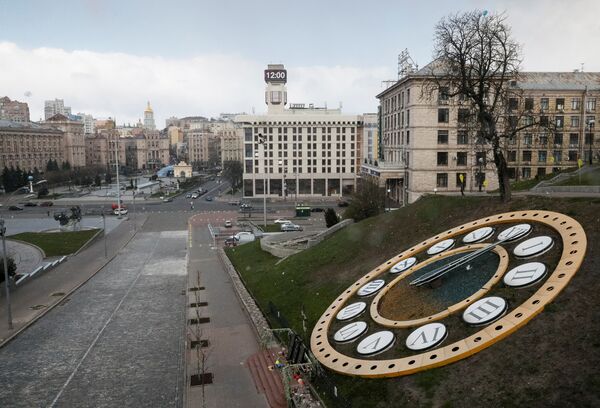 Une horloge affichant midi sur fond de place de l'Indépendance (Maïdan) à Kiev pendant la  pandémie de coronavirus - Sputnik Afrique