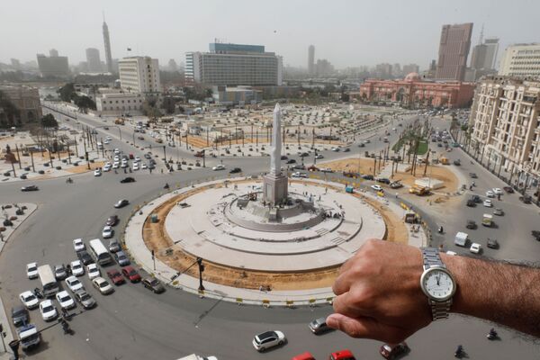 Une montre affichant midi devant la place Tahrir déserte au Caire pendant la pandémie de coronavirus - Sputnik Afrique