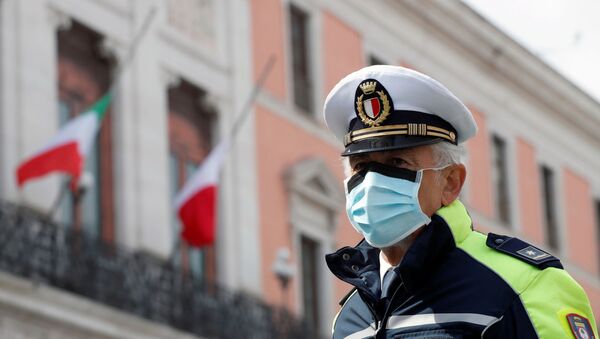 Un officier de police portant un masque de protection à Bari, en Italie - Sputnik Afrique
