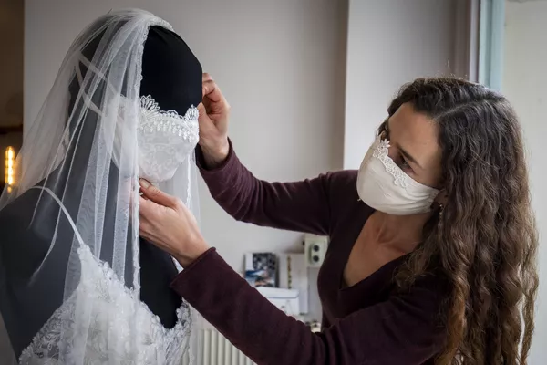 Un designer travaille sur une robe de mariage avec un masque de protection dans un magasin à Berlin Un designer travaille sur une robe de mariage avec un masque de protection dans un magasin à Berlin - Sputnik Afrique