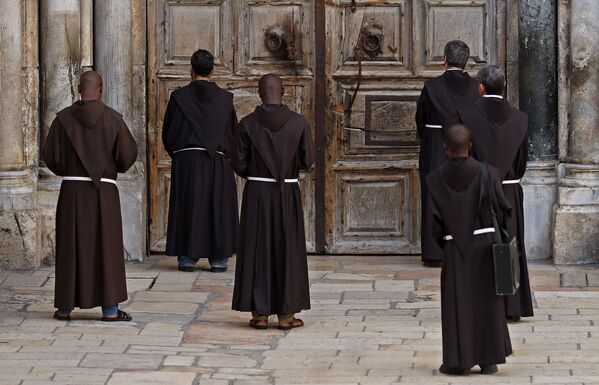 Des moines franciscains pendant la prière devant la porte fermée de l'église du Saint-Sépulcre - Sputnik Afrique