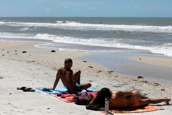 Des gens se reposent à la plage de Treasure Island aux États-Unis malgré sa fermeture à cause de la pandémie de coronavirus - Sputnik Afrique