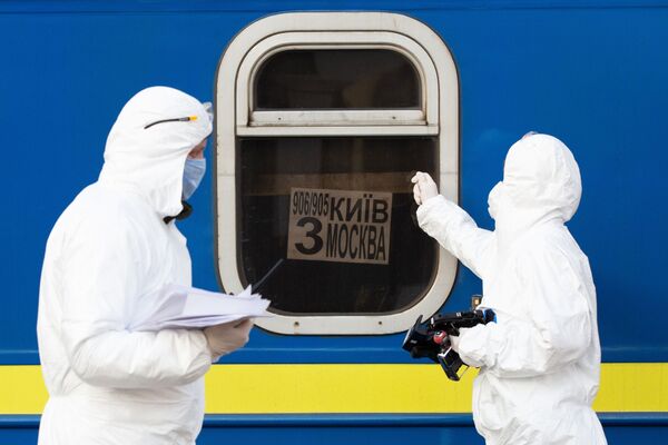 Des médecins portant des tenues de protection biologique devant le train spécial 906/905 Kiev-Moscou-Kiev arrivé à la gare de Kiev - Sputnik Afrique