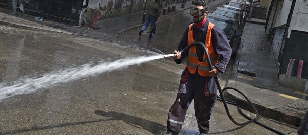 Un employé municipal désinfecte les rues à Alger. - Sputnik Afrique
