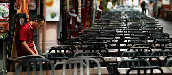 A restaurant promoter waits for customers at the largely empty Chinatown as tourism takes a decline due to the coronavirus outbreak in Singapore February 21, 2020 - Sputnik Afrique