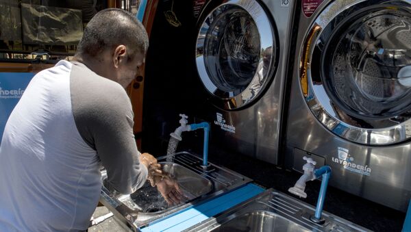 Un homme se lave les mains dans une laverie. - Sputnik Afrique
