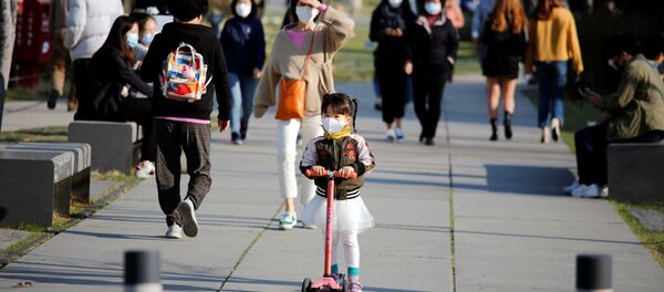 A girl wearing a protective face mask to prevent contracting the coronavirus disease (COVID-19) rides a toy kick scooter at a park in Seoul, South Korea, April 3, 2020 - Sputnik Afrique