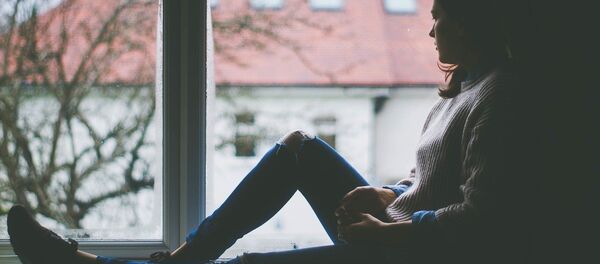 Une jeune femme regarde par la fenêtre Une jeune femme regarde par la fenêtre - Sputnik Afrique