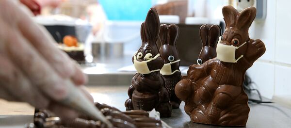 A chocolate maker finishes easter chocolate rabbits with a face mask on April 11, 2020 in Troyes amid the spread of the COVID-19 disease caused by the novel coronavirus. - Sputnik Afrique