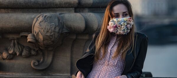 Une jeune femme portant un masque de protection à Prague - Sputnik Afrique