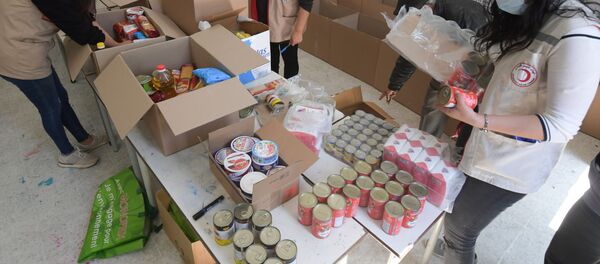 Préparation de cartons de l'aide alimentaire par des membres du Croissant rouge. - Sputnik Afrique