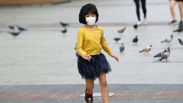 A girl wearing a protective mask runs in a public square in Ho Chi Minh, Vietnam - Sputnik Afrique