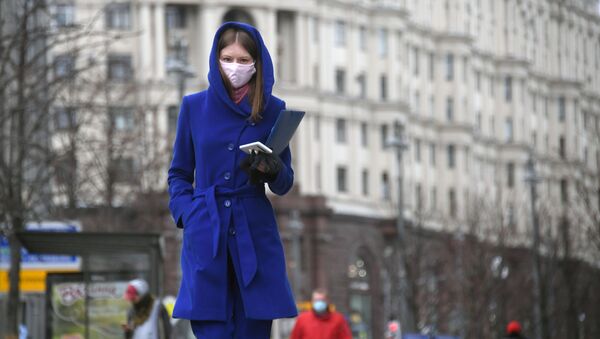 Une femme portant un masque de protection à Moscou - Sputnik Afrique