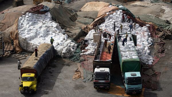 Des dockers chargent des sacs de riz sur les camions au port de Dakar. - Sputnik Afrique