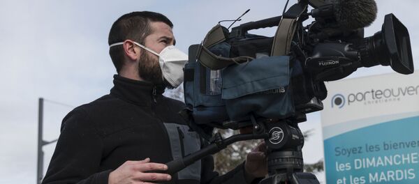 Un caméraman travaille avec un masque de protection. - Sputnik Afrique