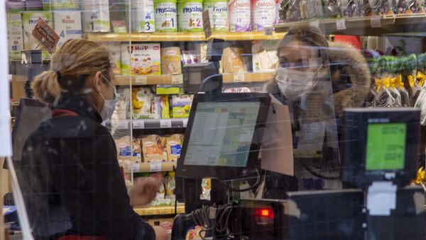 Une femme portant un masque dans un magazin à Paris - Sputnik Afrique