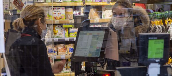 Une femme portant un masque dans un magazin à Paris - Sputnik Afrique