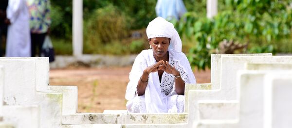 Une femme se recueille devant une tombe à Dakar, Sénégal. - Sputnik Afrique