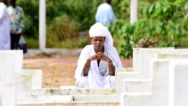 Une femme se recueille devant une tombe à Dakar, Sénégal. - Sputnik Afrique