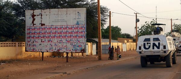 Un véhicule de la Minusma passe devant un placard d'affiches électorales au Mali. - Sputnik Afrique